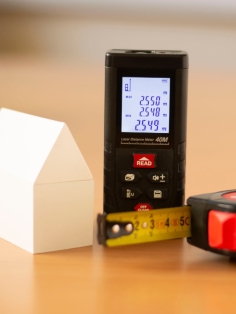 Télémètre laser, mètre ruban et maquette pour mesurer la surface loi Carrez