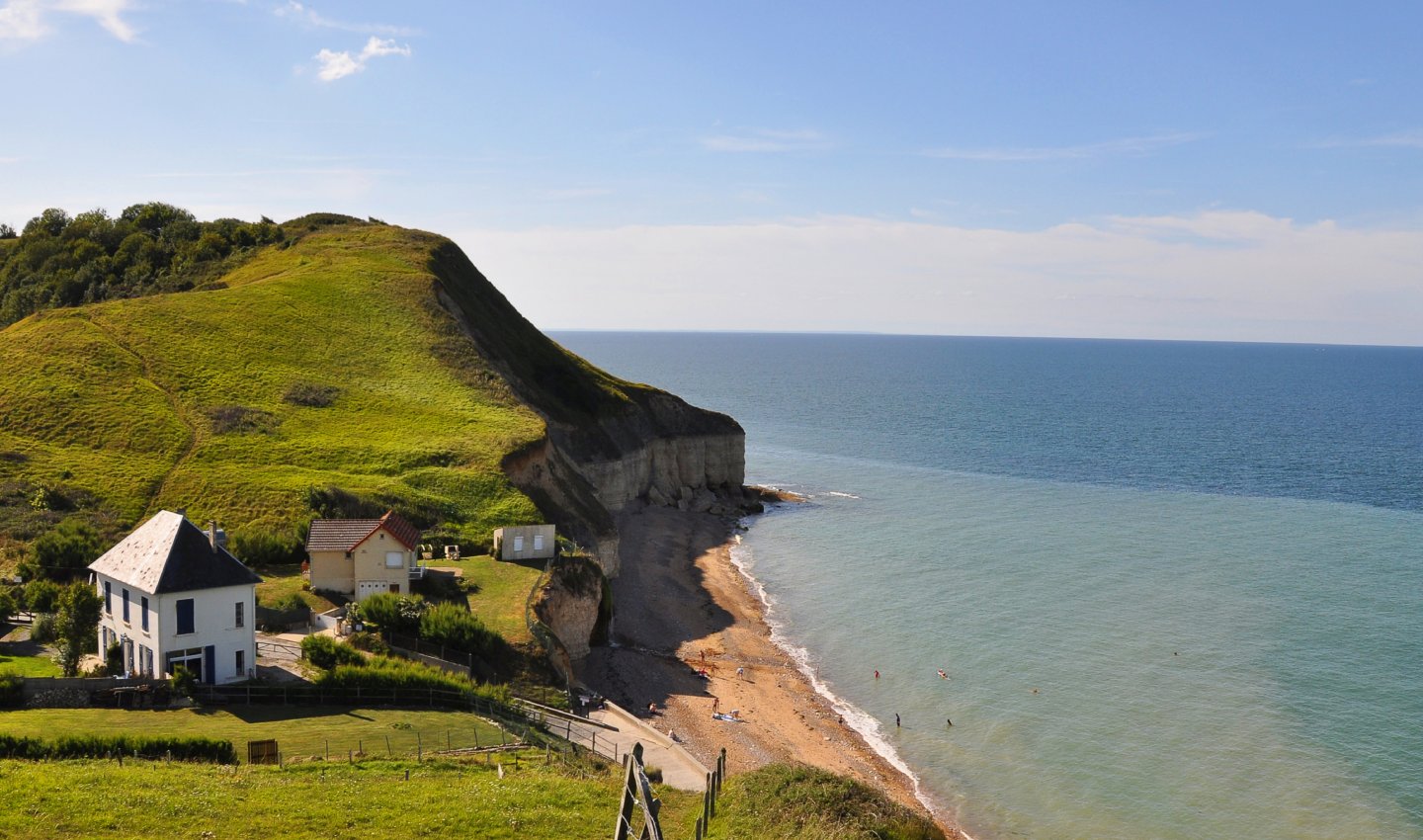 Maison en bord de falaise avec vue sur la mer et plage de galets