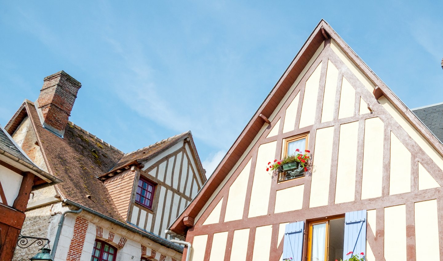 Maisons à colombages fleuries avec toits en tuiles dans un village traditionnel